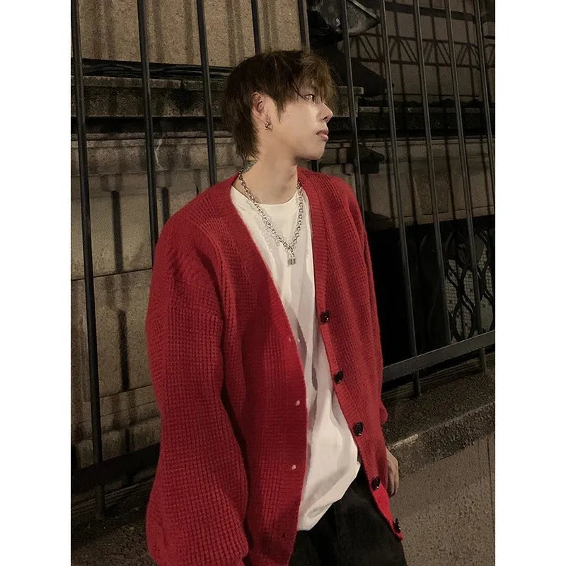 Men's loose fit V-neck knitted cardigan sweater in a solid colour on a hanger.