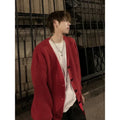 Men's loose fit V-neck knitted cardigan sweater in a solid colour on a hanger.