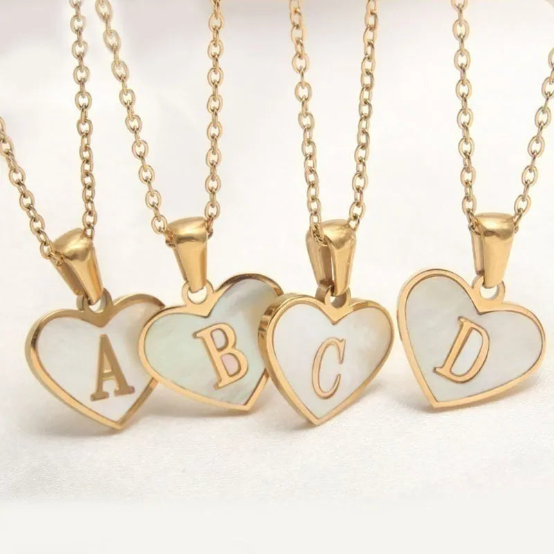 Gold-plated heart necklace with white shell pendant personalised with a letter, on an adjustable chain.