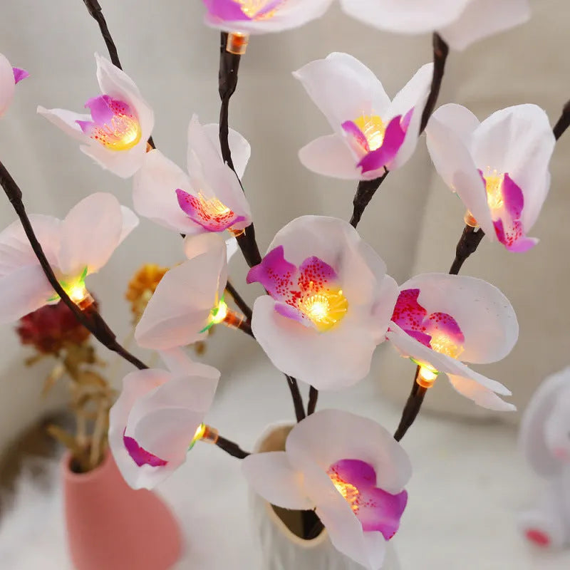 Pink LED phalaenopsis orchid branch decorative light, 65 cm tall, on a table.