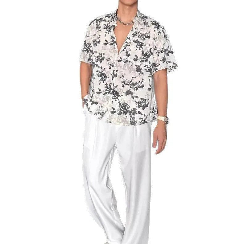 Man wearing a loose black floral print short sleeve casual shirt with a cardigan style open front.