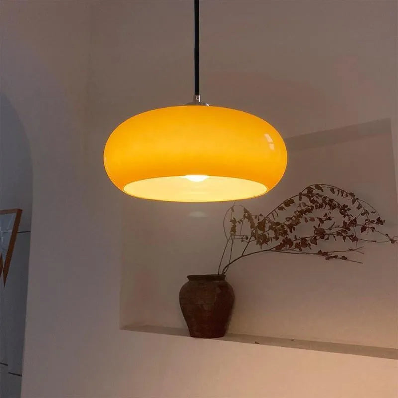 Three-headed Bauhaus pendant light with milky white glass egg tart shades hanging from a ceiling.