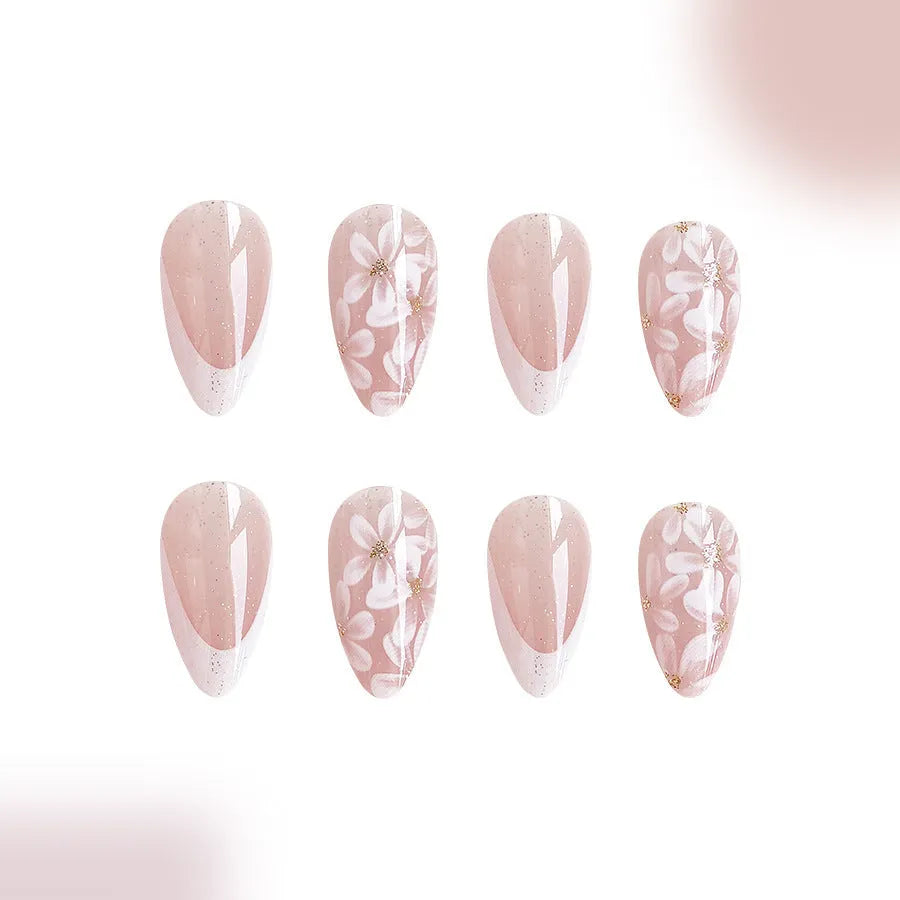 Short almond shaped removable false nails with glossy French tips and glitter flower decoration, colour C625.