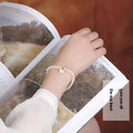 Women's freshwater pearl bracelet with fan-shell alloy clasp in 16cm size on wrist.