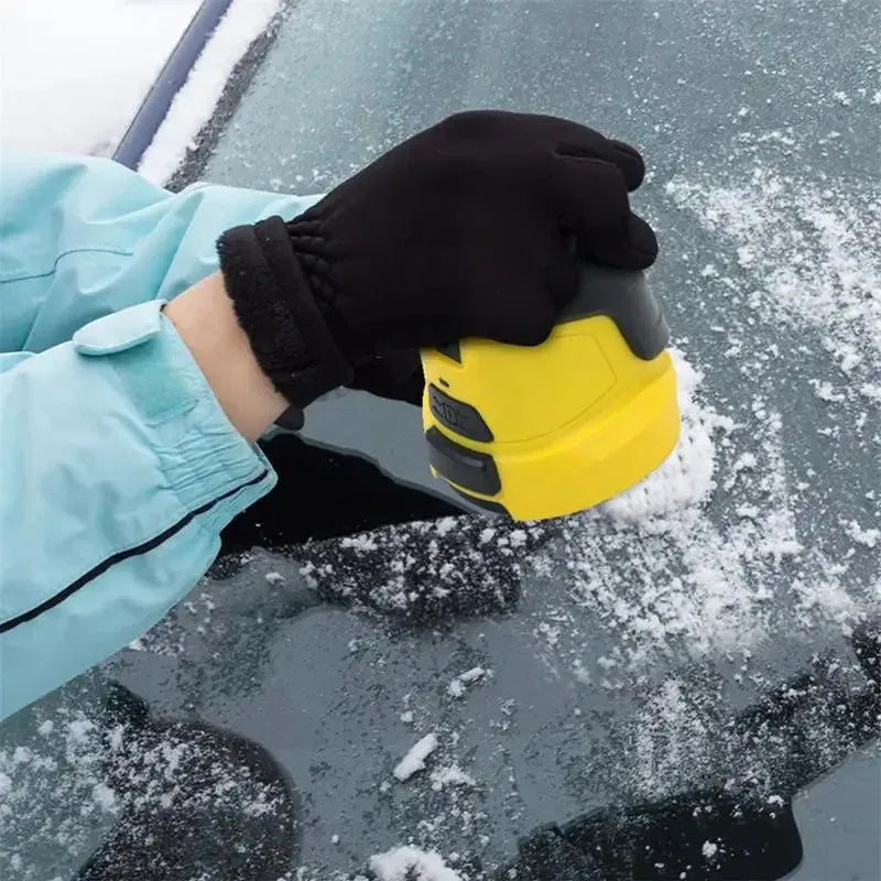 Yellow cordless electric ice scraper with USB charging cable on a car windscreen.