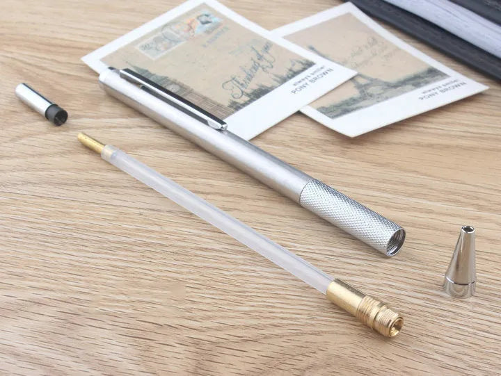 Metal automatic mechanical pencil on a surface, shown with multiple lead size indicators including 0.5mm and 2.0mm.