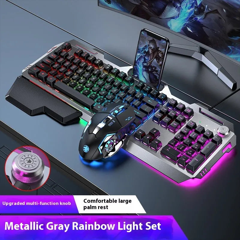 Aluminium gaming keyboard with volume knob, shown in metal grey with RGB lighting alongside optional macro mouse and headset.