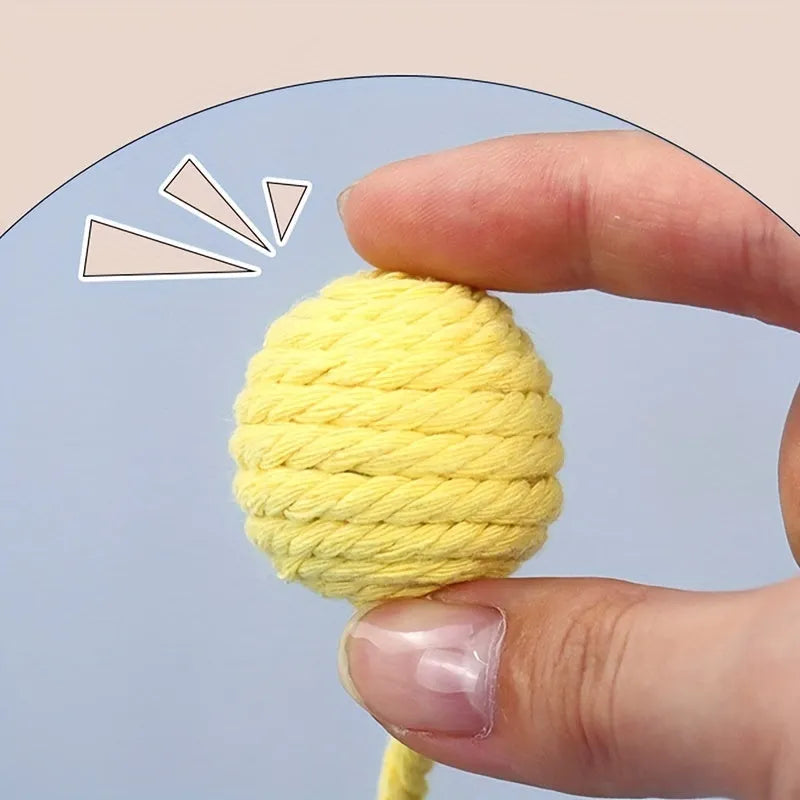 Coloured cat toy ball with rope attached and built-in bell inside, shown in green, pink, purple, and yellow options