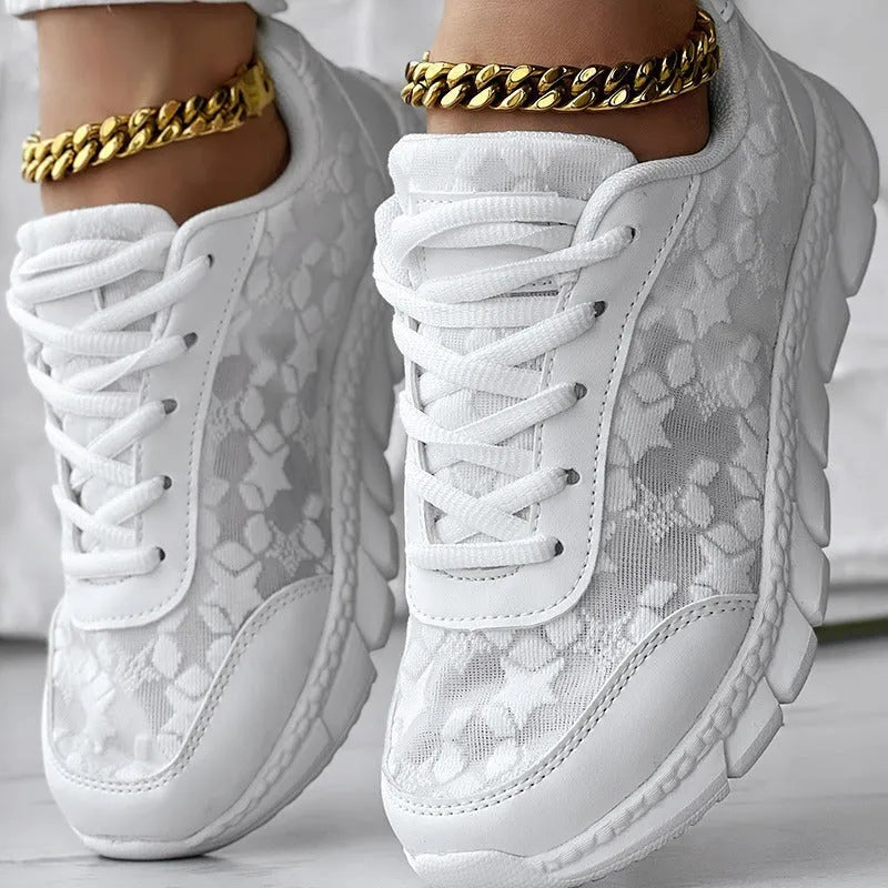 Women's white canvas running shoes with soft sole and flat heel on a plain background.
