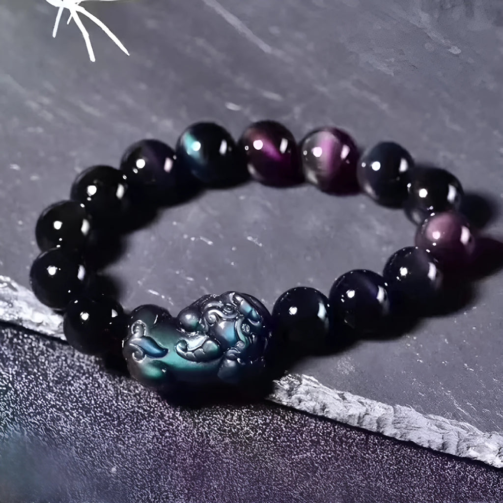 Natural obsidian stone bead bracelet with adjustable black cord on a wrist.
