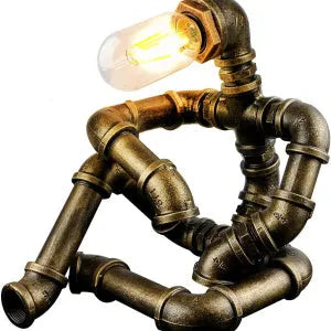 Green bronze vintage robot table lamp with industrial iron pipe design on wooden desk