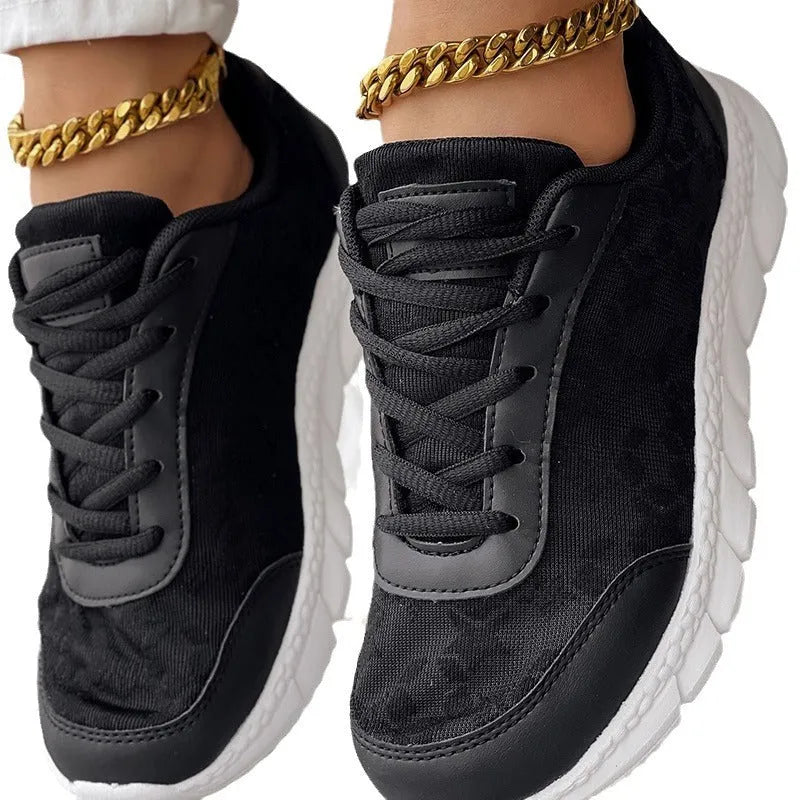Women's white canvas running shoes with soft sole and flat heel on a plain background.