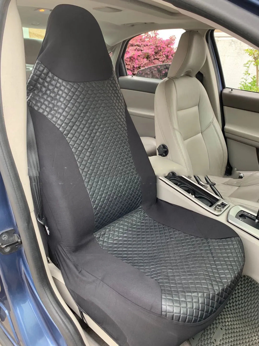 Black quilted automotive seat cover with PU and polyester construction showing plastic hooks