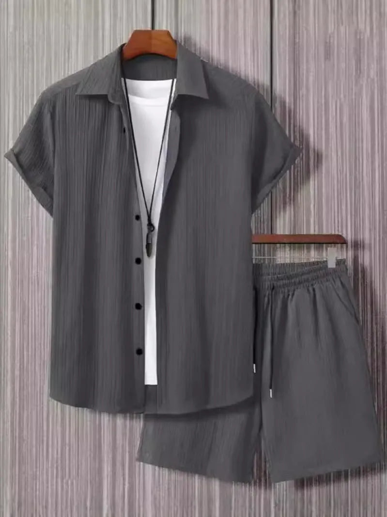 Man wearing a grey jacquard short-sleeve suit jacket and matching shorts.