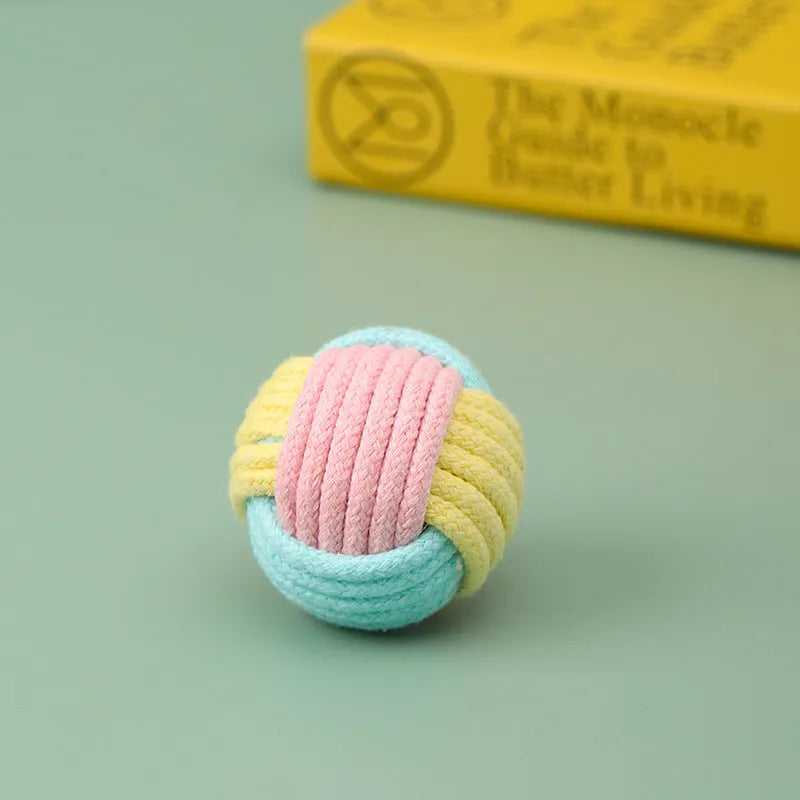 Small handmade blue and pink cotton plush ball cat toy for play and teeth grinding, shown next to a 5cm scale.