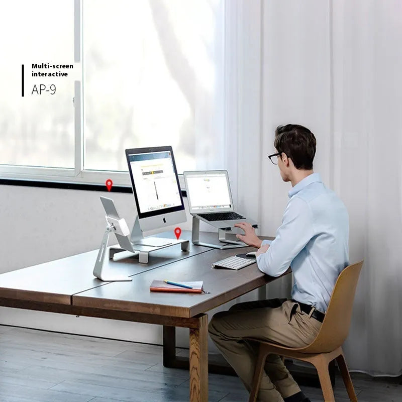 Black aluminium laptop stand on desk supporting silver laptop at improved viewing height