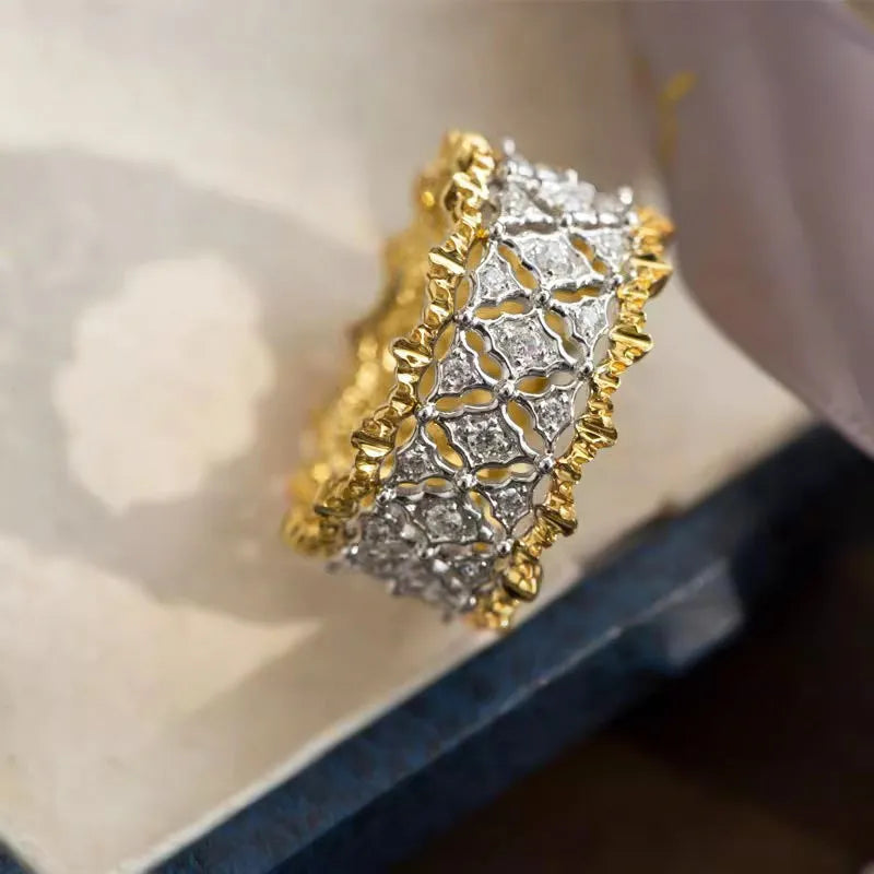 Geometric gold two-tone zircon ring on a copper band, showing round detail.