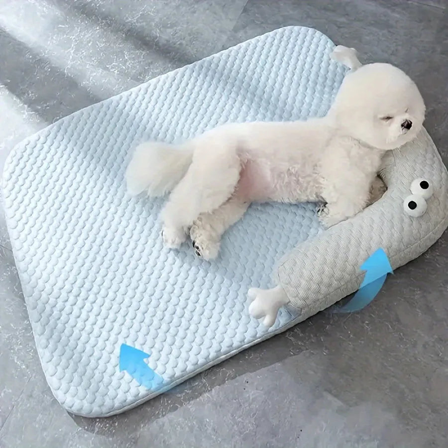 Blue pet bed cushion with a big-eyed monster design on a wooden floor.
