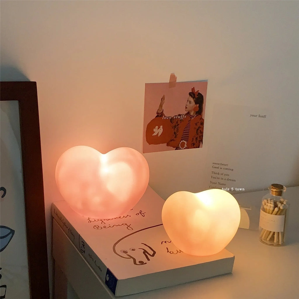 Small white vinyl atmosphere lamp with glowing warm light on a table.
