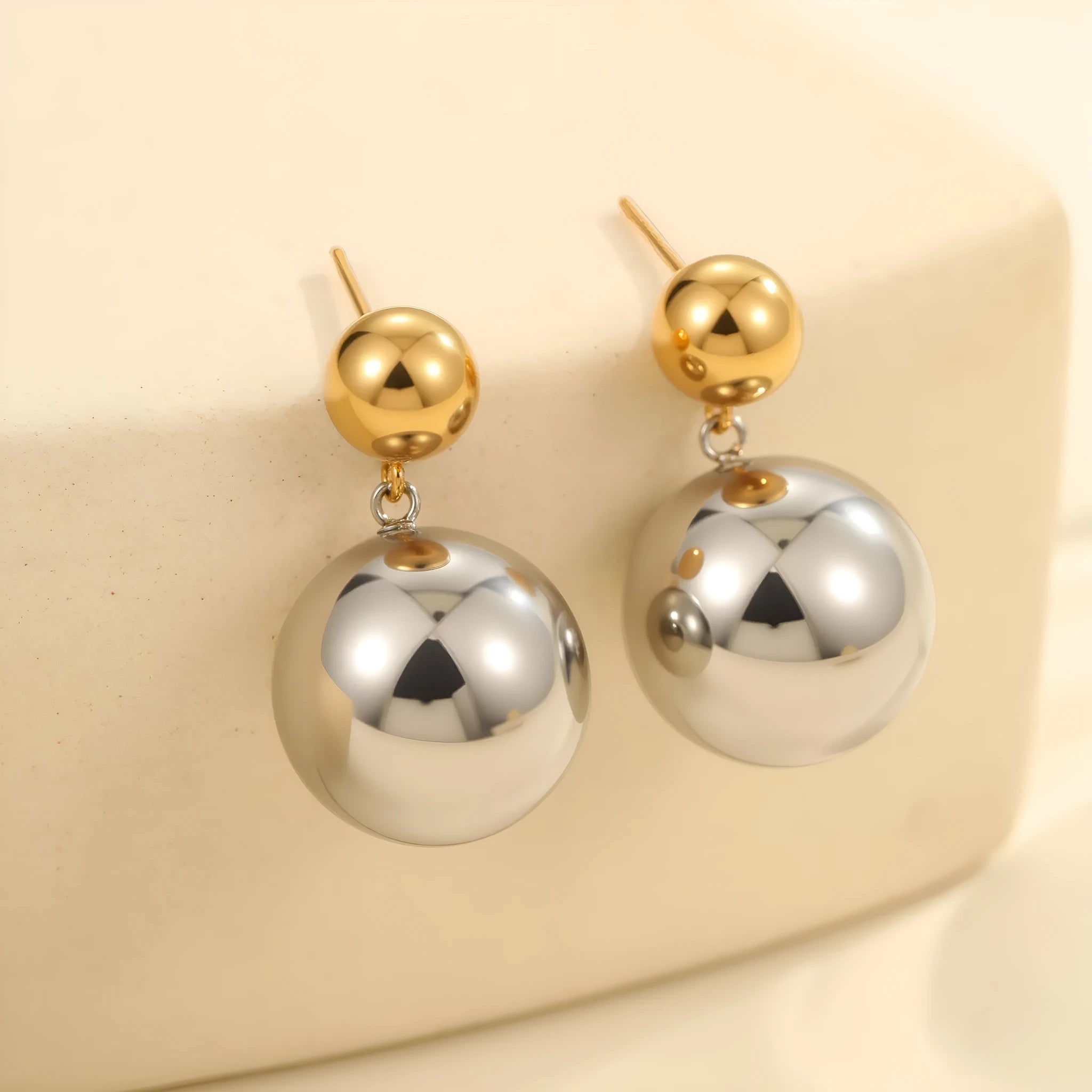 A pair of round bead stainless steel stud earrings with a colour-block geometric design.