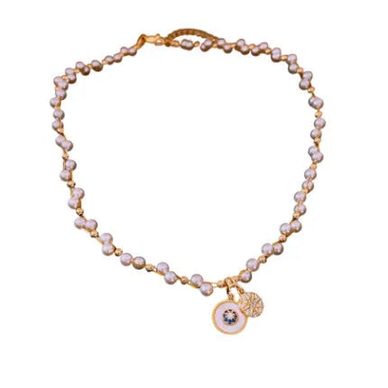Gold electroplated clavicle necklace with round geometric pendant containing zircon inlay and imitation pearl centrepiece