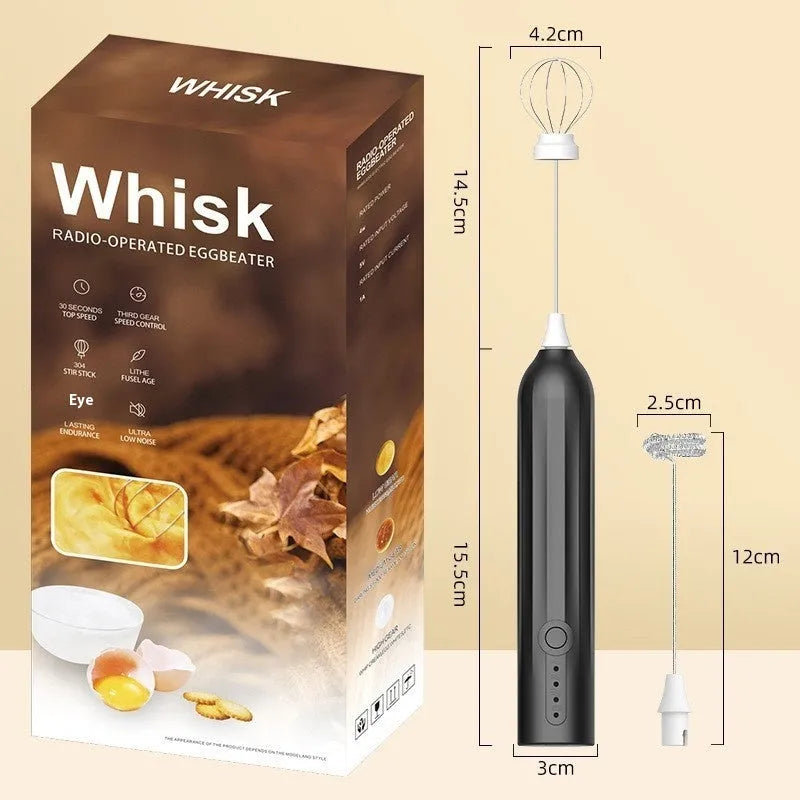 Compact black handheld USB rechargeable milk frother with stainless steel whisk on a kitchen counter.