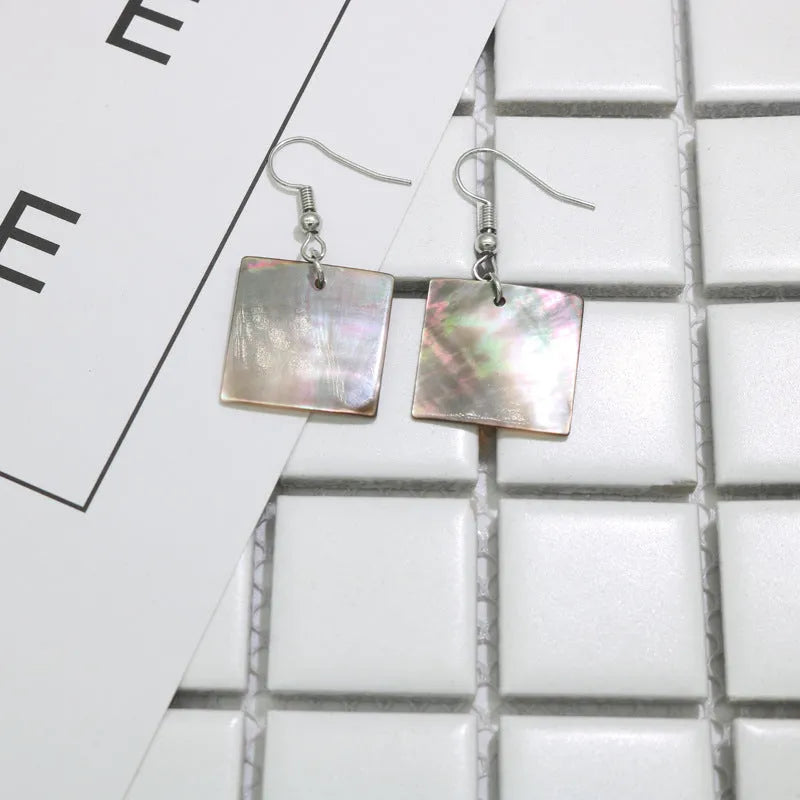 A pair of women's geometric earrings made from natural shell in a retro style.