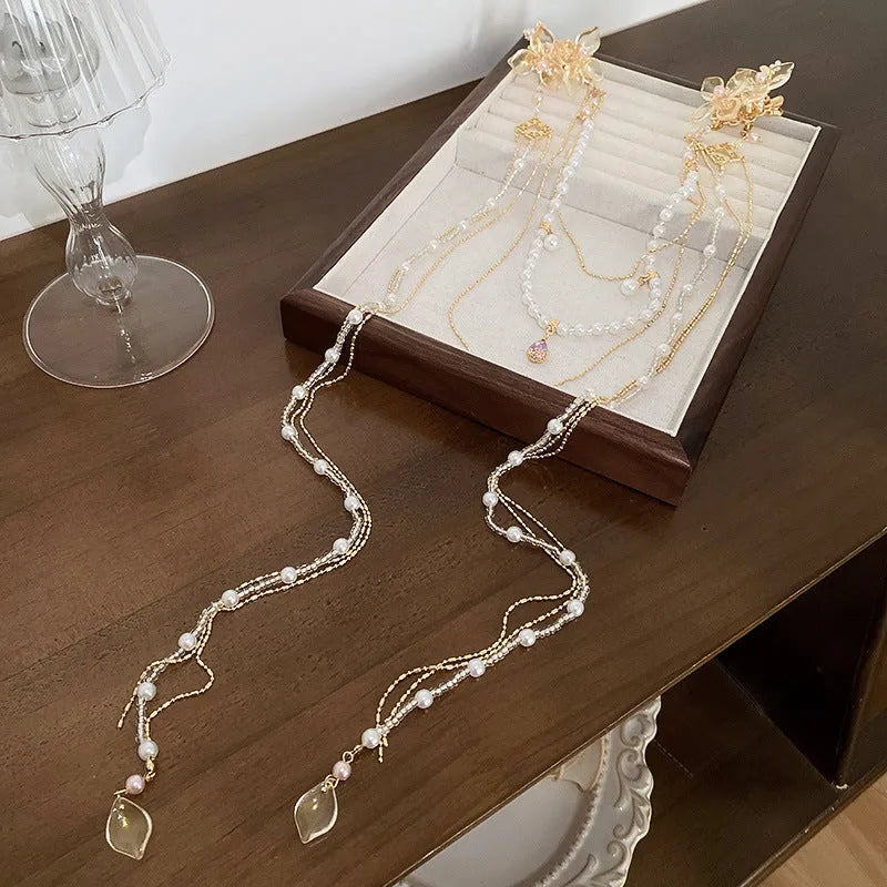 Gold women's hairpin with acrylic pearl, diamond flower decoration, and long dangling tassel.