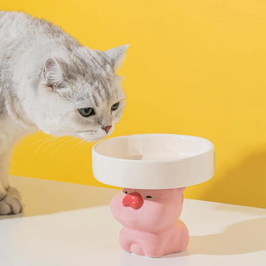 Raised ceramic cat food bowl in animal design, showing elevated height and wide bowl.