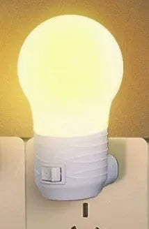 Plug-in bedside baby night light in white, blue, or pink shell with round design on a table