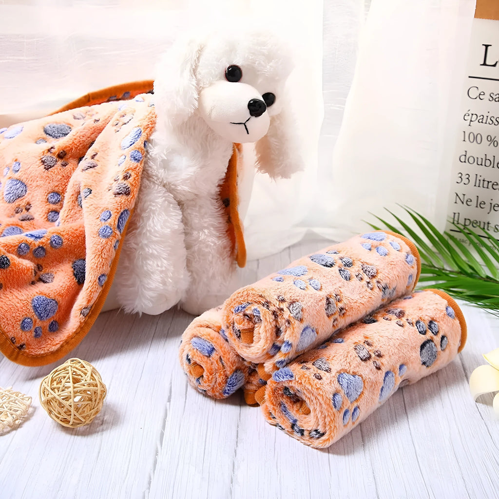 Coral fleece dog blanket with paw print design, shown in camel colour, laid flat.