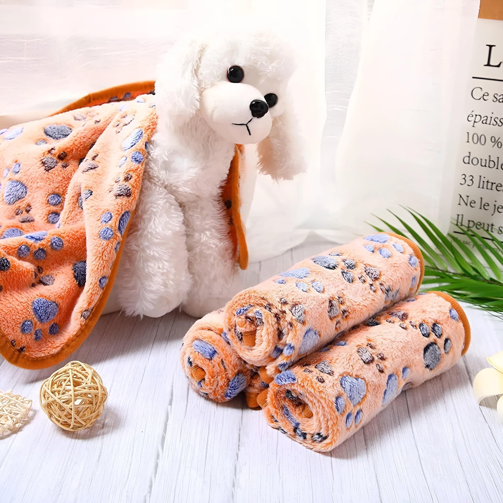 Coral fleece dog blanket with paw print design, shown in camel colour, laid flat.