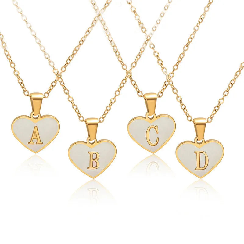 Gold-plated heart necklace with white shell pendant personalised with a letter, on an adjustable chain.
