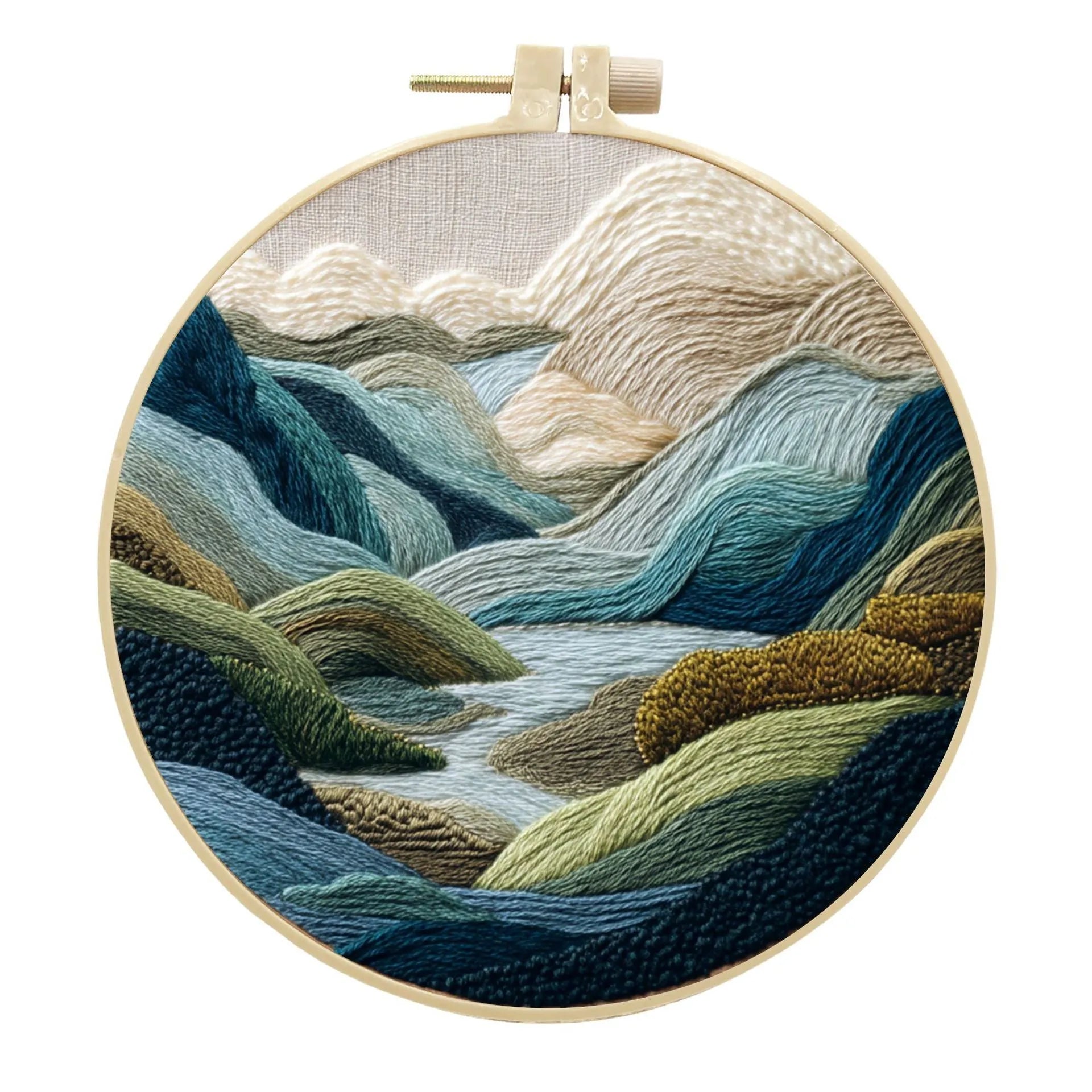 DIY landscape embroidery kit with cotton fabric, bamboo frame, threads and needles arranged for crafting