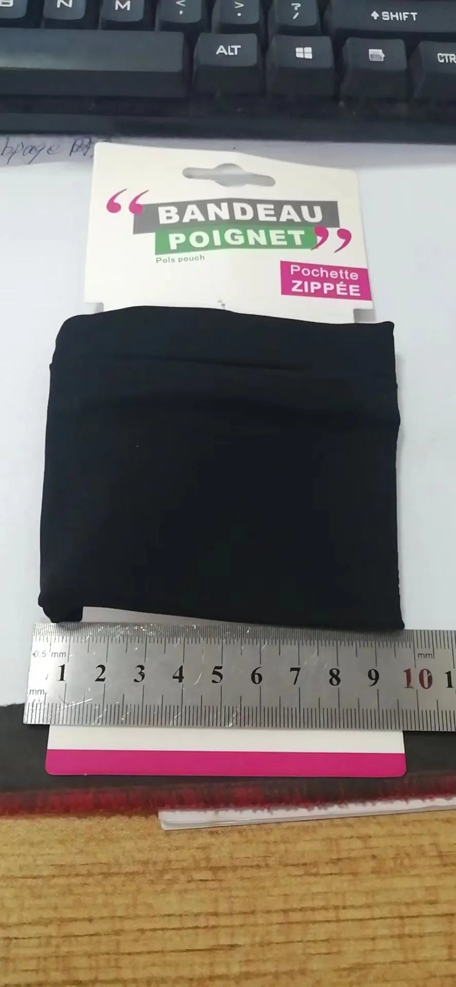 Wrist bag armband sleeve for mobile phone, shown in packaging, dimensions 10 by 10.5 cm.