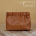 Leather travel toiletry bag in caramel mocha colour showing storage compartments and decorative letter details