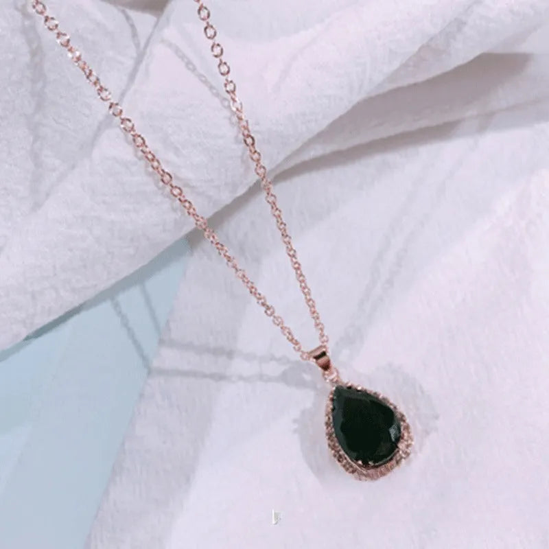 Pink water drop shaped rhinestone necklace with rose gold electroplated alloy pendant on white background