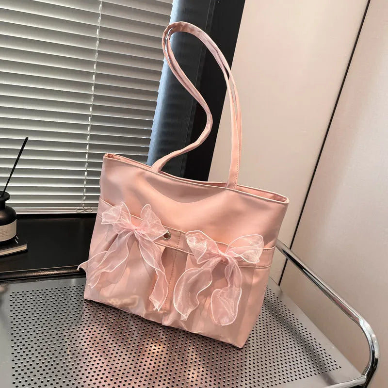 Black and pink college style bow tote bag with double straps and a front view.