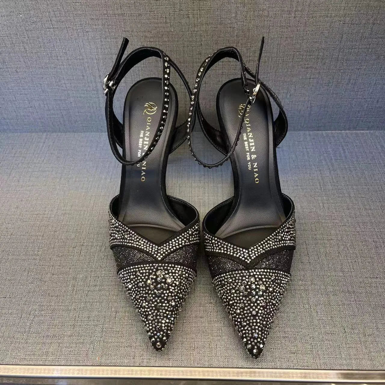 Women's black hollow high heels with red sole, stiletto heel and pointed toe design