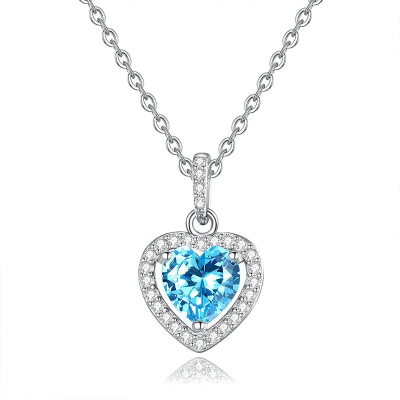 Women's sterling silver necklace with heart-shaped pendant containing natural gemstone on adjustable cross chain