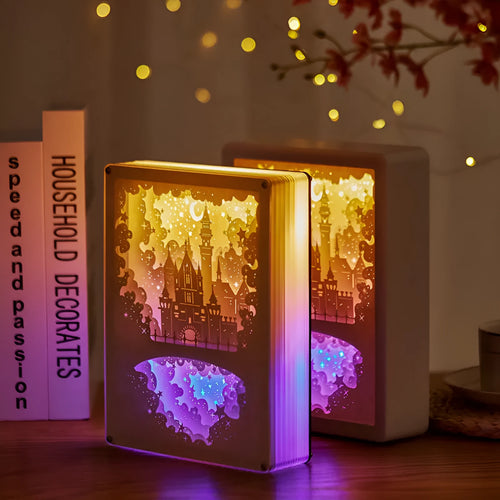 Modern bedside USB night light with paper carving design and remote control on a table.