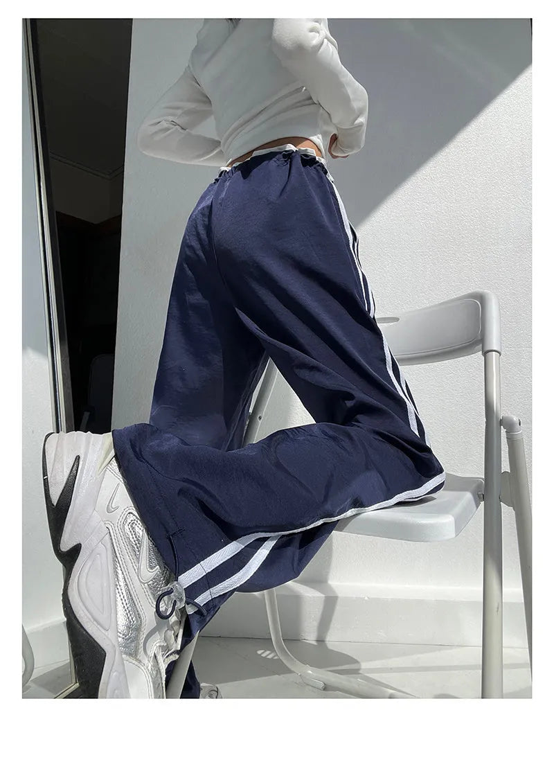 Women's navy blue loose straight leg trousers with ribbon parallel bars detail on the leg.