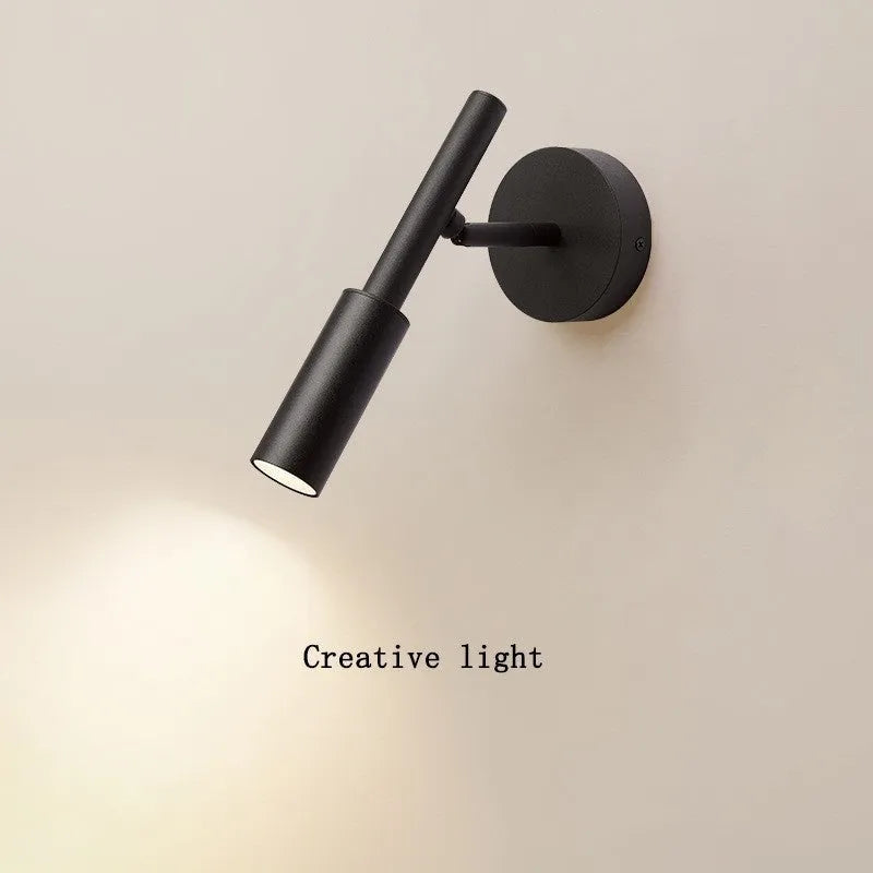 Modern wrought iron wall lamp in black or white, 100mm by 230mm, with three colour light options.