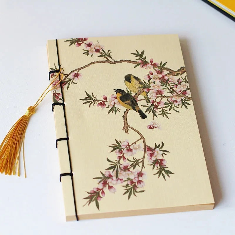 A5 antique wire-bound notebook with retro painting cover, open to show Kraft paper pages