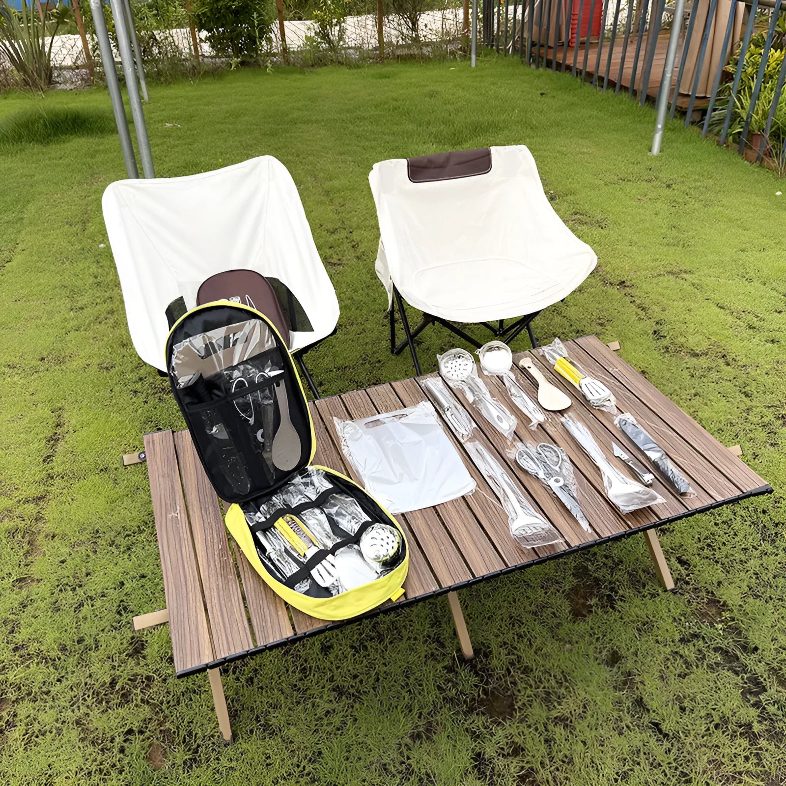 12-piece stainless steel portable picnic kitchenware set in a khaki storage bag.