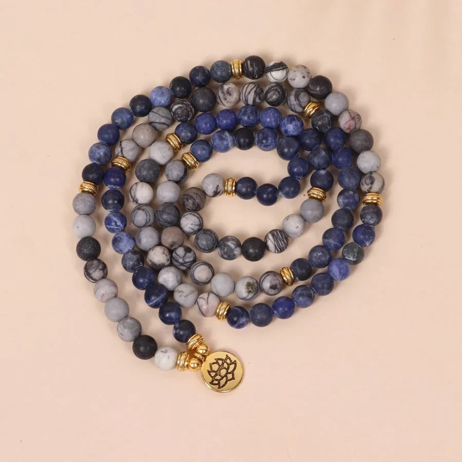 Close-up of a blue patterned network stone bead multi layer alloy bracelet on a wrist