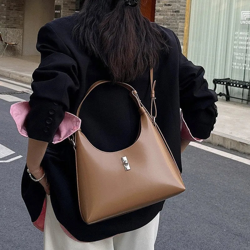 Genuine leather dumpling-shaped crossbody shoulder bag in apricot colour with a front sandwich pocket.