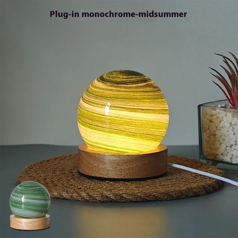 Planets themed USB night light with modern design and three-colour dimming on bedside table.