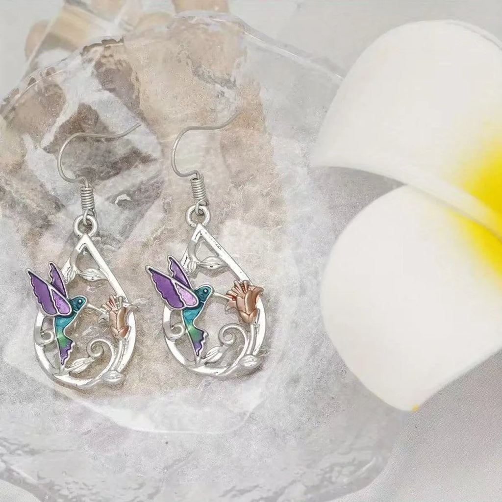 White electroplated copper hummingbird necklace and earring set with animal motifs on a neutral background