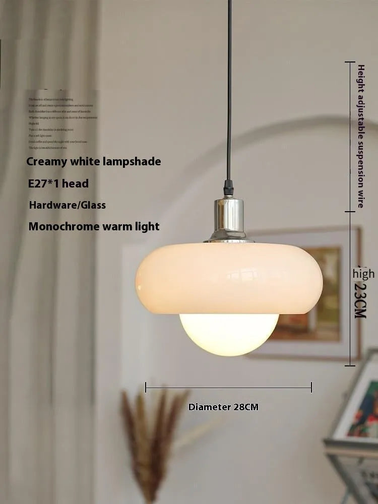Three-headed Bauhaus pendant light with milky white glass egg tart shades hanging from a ceiling.